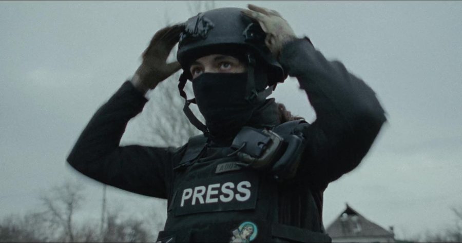 A press photographer adjusting a helmet